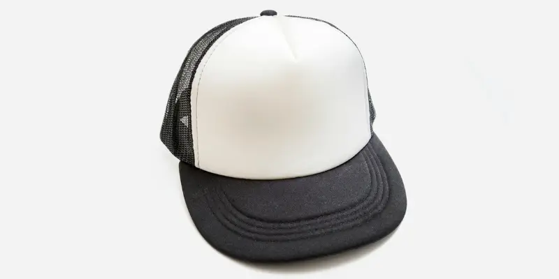 A black and white trucker cap placed on a light gray background