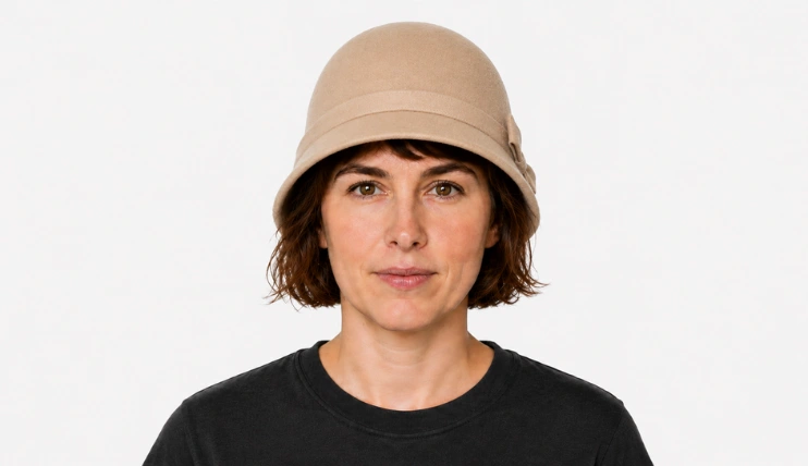 Woman with short hair wearing a cloche hat fitted close to the head with the brim just above the eyebrows