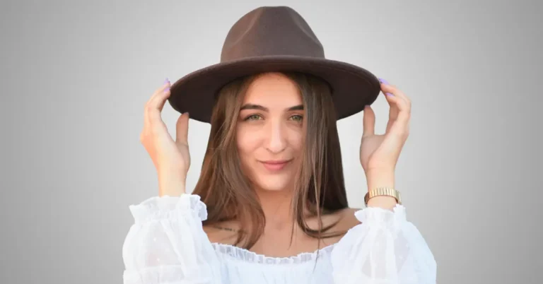 Woman with long straight hair wearing a brown wide-brim hat, showing how to style a hat with long hair