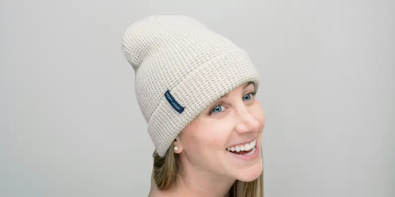 26 Different Types of Hats Explained (With Names, Styles & Pictures) 8 Smiling woman wearing a light beige beanie cap