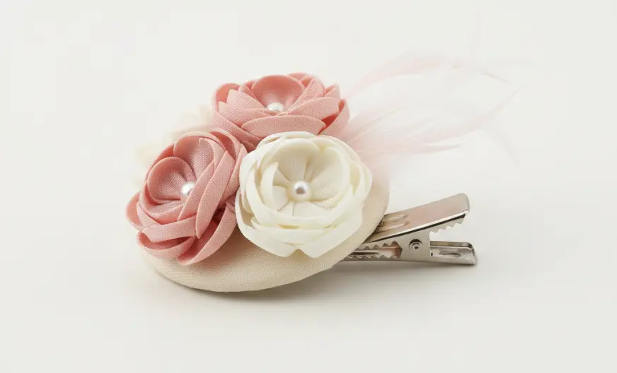 Clip fascinator placed on a flat surface showing the decorative front and hair clip attachment