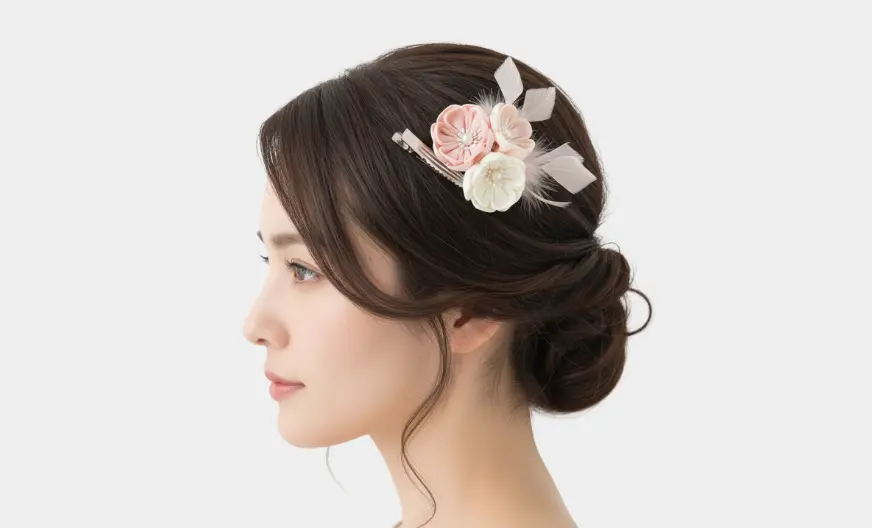 adult woman with side-swept hair wearing a clip fascinator above the temple, slightly tilted along hair flow, light background