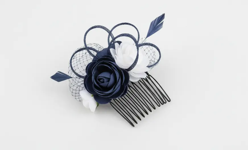 Comb fascinator hair accessory placed flat on a light background with decorative fabric detail and visible comb teeth