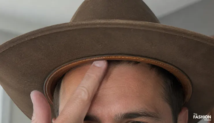 How to Wear a Cowboy Hat Correctly 6 Sliding one finger between the inner band and forehead to check if a cowboy hat fits properly