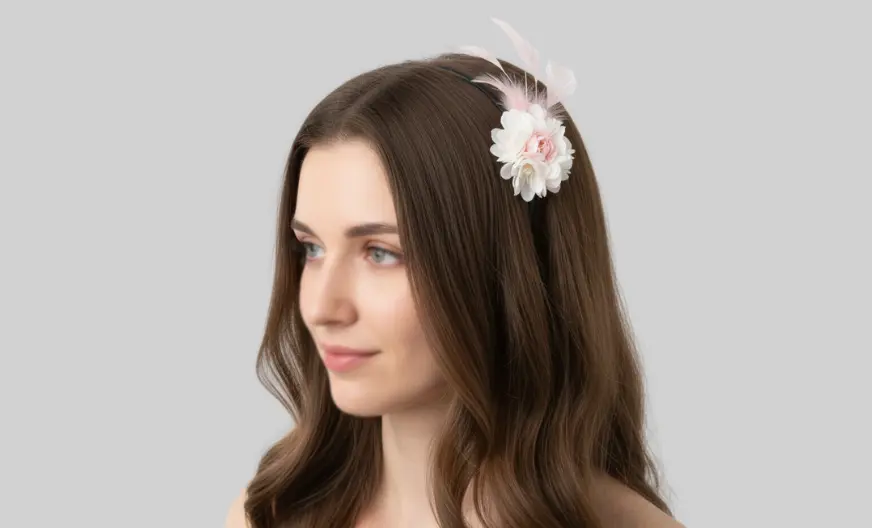 adult woman with hair down wearing a headband fascinator slightly tilted to the side, light background