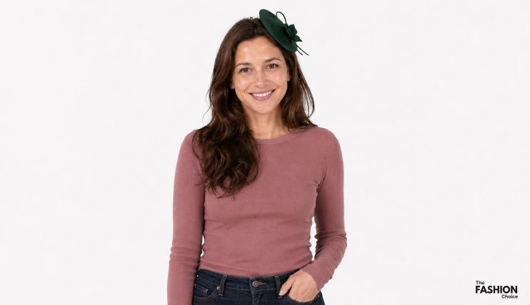 Woman wearing a small forest green fascinator with jeans and a dusty mauve long sleeve top, showing how to style a fascinator casually with everyday clothes