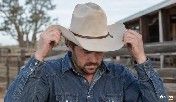 How to Wear a Cowboy Hat Correctly 4 Person putting on a cowboy hat with both hands