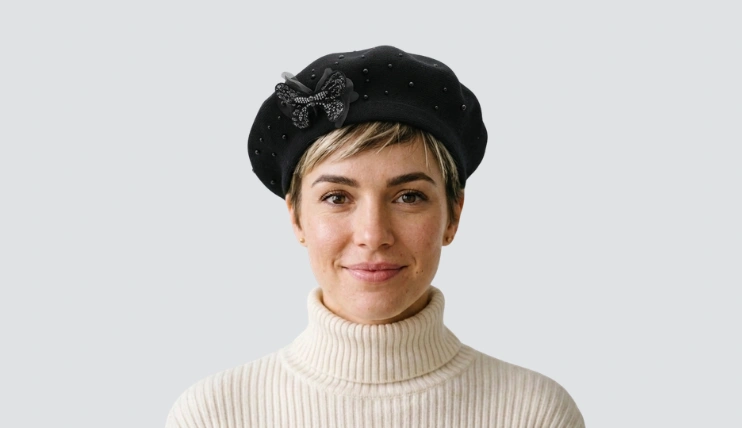 Woman with a pixie haircut wearing a black beret