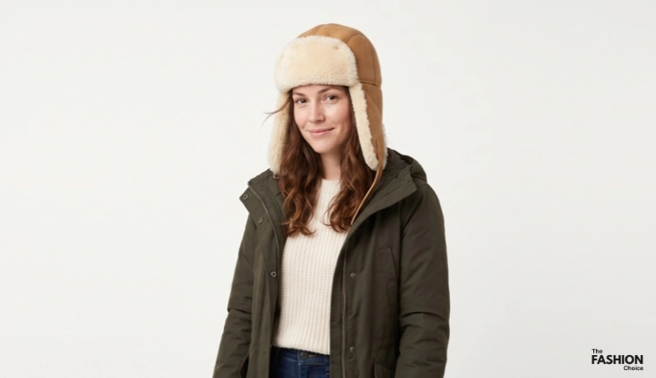 7 Best Winter Hats for Short Hair 16 Woman wearing a tan leather aviator ushanka with thick ivory sheepskin lining and earflaps