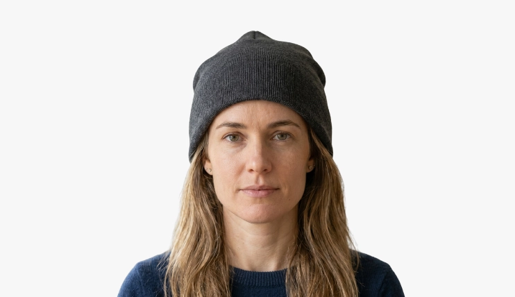 Woman with square face shape wearing a slouchy beanie on a plain background