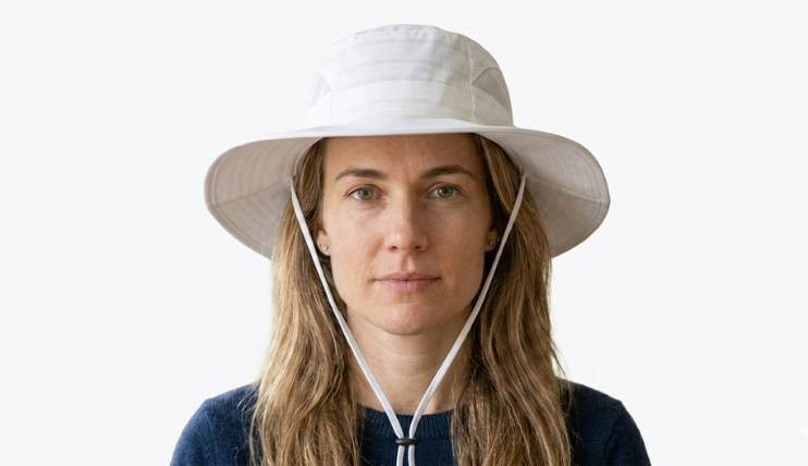 Woman wearing a best wide brim sun hat with square face shape on a plain background