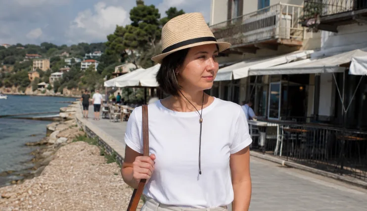 Woman with short hair wearing a straw fedora on a summer vacation